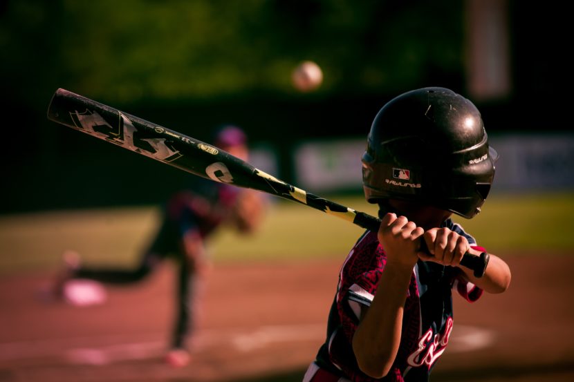 A young boy holding a baseball bat on top of a field.