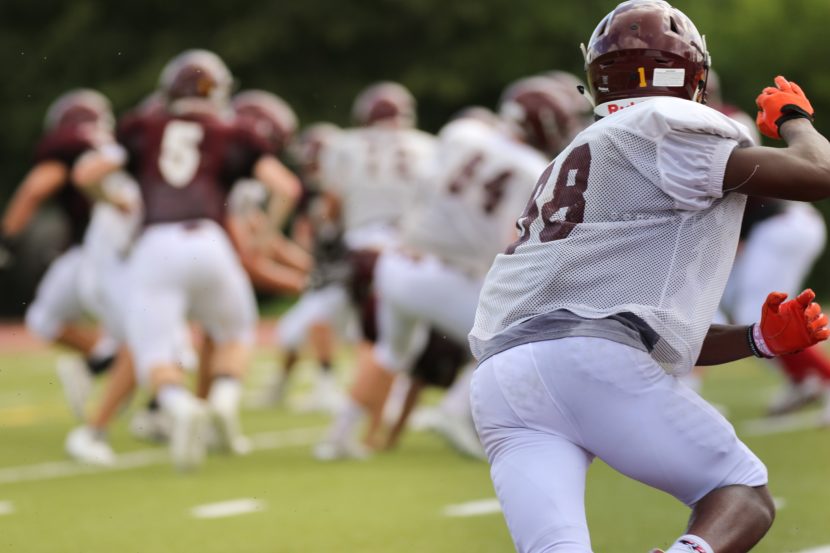 A group of football players are playing on the field.